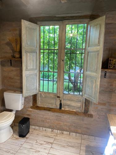 a bathroom with a toilet and a window at Casa Terra in Ciudad Lujan de Cuyo