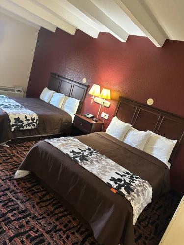 a hotel room with two beds and a red wall at Rodeway Inn in Zanesville