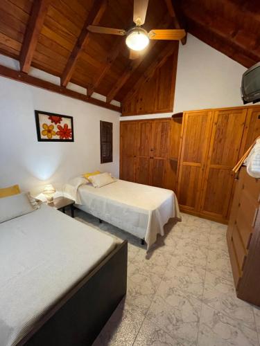1 dormitorio con 2 camas y ventilador de techo en Apartamento Remansum en Santa Rosa de Calamuchita
