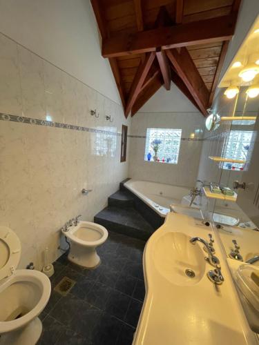 a bathroom with two toilets and a sink and a tub at Apartamento Remansum in Santa Rosa de Calamuchita