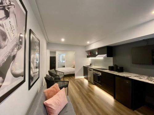 a room with a kitchen and a living room with a couch at Luxury inner-west flat w/ breakfast and coffee included! in Sydney