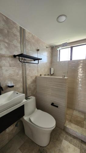 a bathroom with a white toilet and a sink at La terraza departamentos 402 in Cuenca