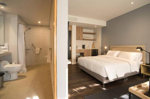 a bedroom with a white bed and a bathroom at Calucé hab 409 by Letoh in Chía