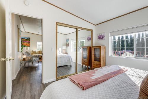 - une chambre avec un lit et un miroir dans l'établissement Charming Petaluma Cottage with Grill Near Wineries, à Petaluma