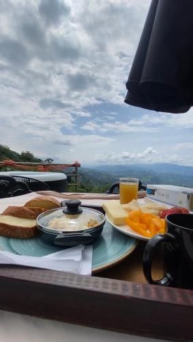 a table with plates of food on a table with a view at Andino Glamping in La Peña