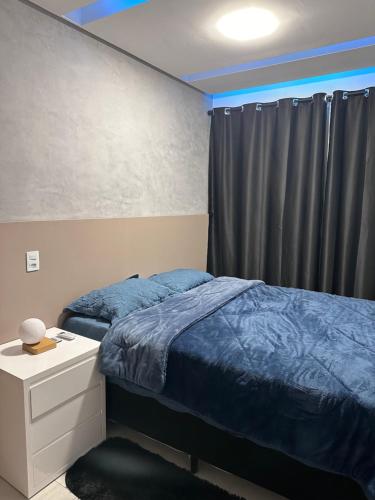 a bedroom with a bed and a curtain and a dresser at Apartamento Completo Jatiúca in Maceió