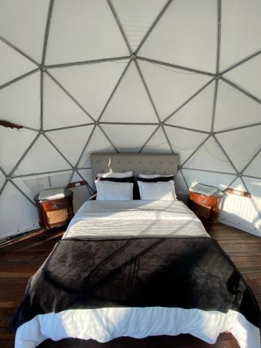 a bedroom with a bed in a triangular shaped room at Andino Glamping in La Peña