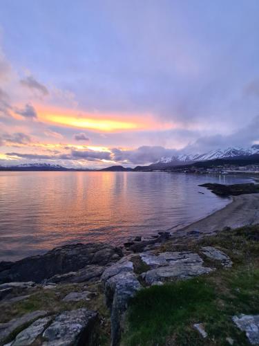 a sunset on the shore of a body of water at Hotel Tierra del Fuego in Ushuaia