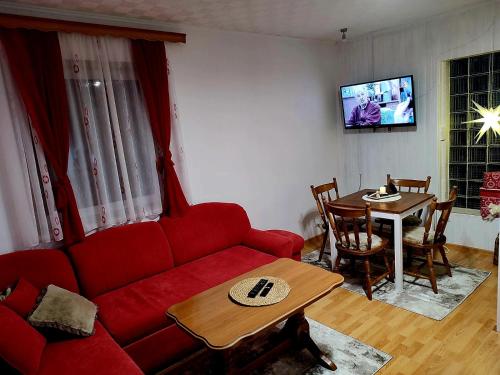 sala de estar con sofá rojo y mesa en Holiday home Ravna Planina en Pale