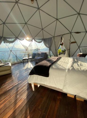 a bedroom in a tent with a bed in it at Andino Glamping in La Peña