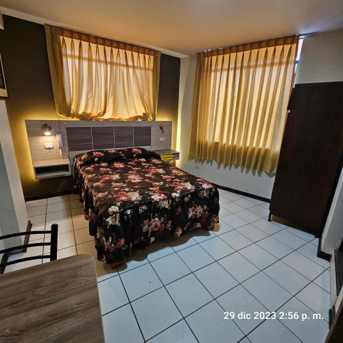 una camera da letto con un letto con copriletto floreale di Hostal La Cascada a Lima