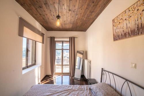 a bedroom with a bed and a wooden ceiling at Valtesiniko View in Valtessiniko 