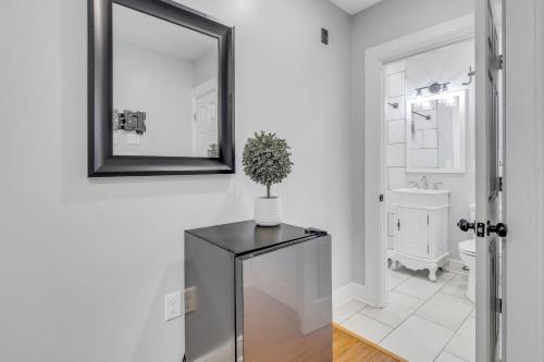 a bathroom with a mirror and a table with a plant on it at Fairmount Oasis 1BR Haven in Philadelphia