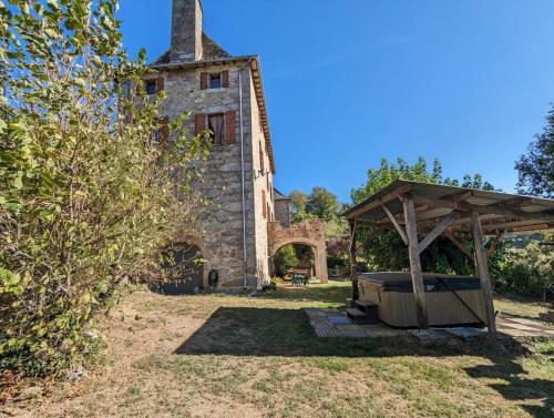 an old stone building with a gazebo in a yard at La Châtaigne Gîte of Domaine de La Bertrandie in La Fouillade