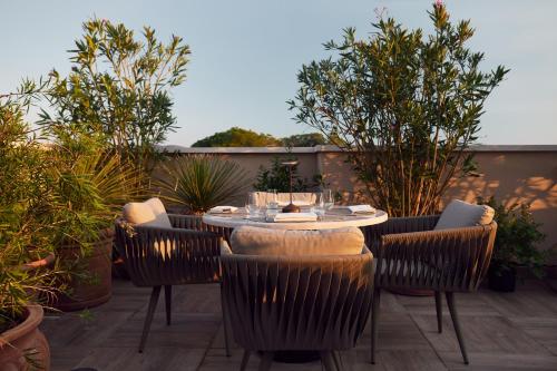 a patio with a table and chairs and plants at La Fleur Boutique Hotel in Tivat