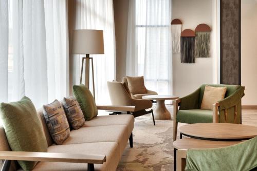 a living room with chairs and a couch and tables at TownePlace Suites by Marriott Show Low in Show Low