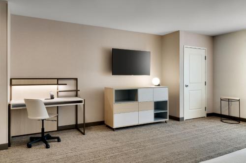 a room with a desk and a bed and a tv at TownePlace Suites by Marriott Show Low in Show Low