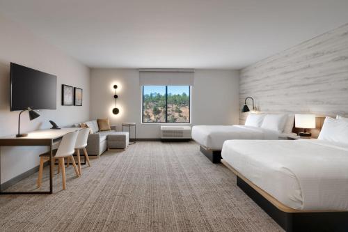 a hotel room with two beds and a couch at TownePlace Suites by Marriott Show Low in Show Low