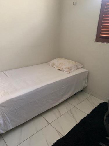 - un lit non aménagé dans une chambre dotée d'un mur blanc dans l'établissement Apartamento bancários, à João Pessoa
