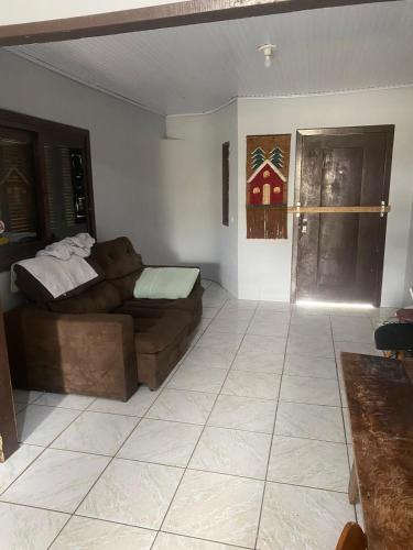 ein Wohnzimmer mit einem Sofa und einem Bett in der Unterkunft Casa de veraneio in Arroio do Sal