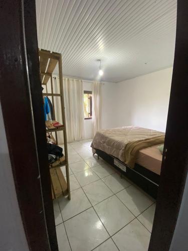 ein Schlafzimmer mit einem Bett und einer Leiter darin in der Unterkunft Casa de veraneio in Arroio do Sal