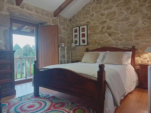a bedroom with a bed and a stone wall at Jardim da Rosa in Monção