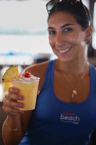 a woman in a blue shirt holding a drink at The Suites at Fishermen's Village - 2 Bedroom Suites in Punta Gorda