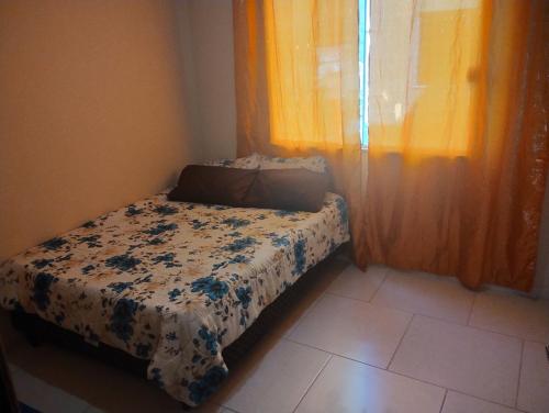 a small bed in a room with a window at Apartamento Mangaratiba 2 suites in Mangaratiba