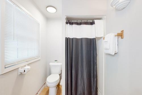 łazienka z zasłoną prysznicową i toaletą w obiekcie The Pup House w mieście Manitowish Waters