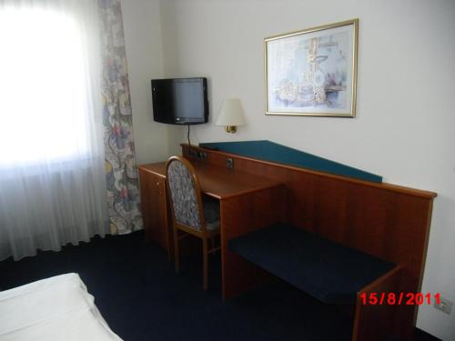 a hotel room with a desk and a television at Centralhotel Ratingen in Ratingen