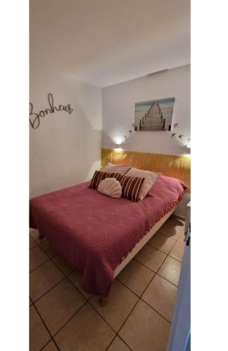 une chambre avec un lit avec une couverture rouge dans l'établissement Résidence Gascogne \ appartement 116, à Biscarrosse