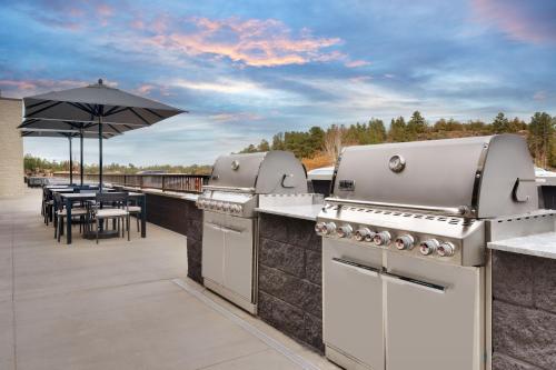a patio with a grill and a table with an umbrella at Fairfield by Marriott Inn & Suites Show Low in Show Low