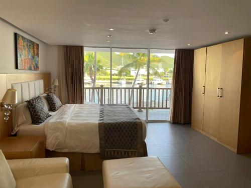 a hotel room with a bed and a balcony at Port de Plaisance Resort, Trademark Collection by Wyndham in Philipsburg