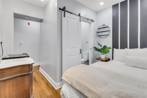 a white bedroom with a bed and a sink at 1 BR Patio Paradise in Central City in Philadelphia