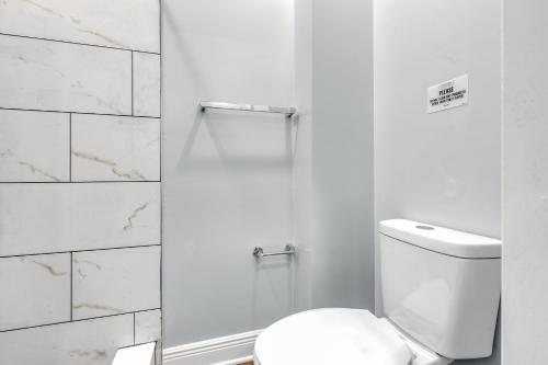 a white bathroom with a toilet and a shower at 1 BR Patio Paradise in Central City in Philadelphia