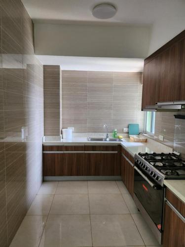 a large kitchen with a stove and a sink at Robert's Place Block A 202 in Baatsona