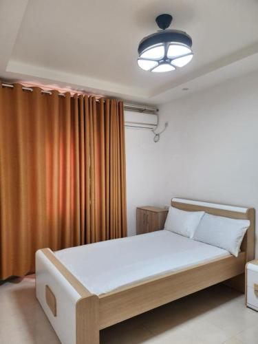 a bedroom with a large bed with a light at Robert's Place Block A 202 in Baatsona