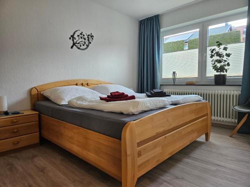 a wooden bed in a bedroom with a window at Ferienwohnung Hoch im Harz, Altenau in Altenau