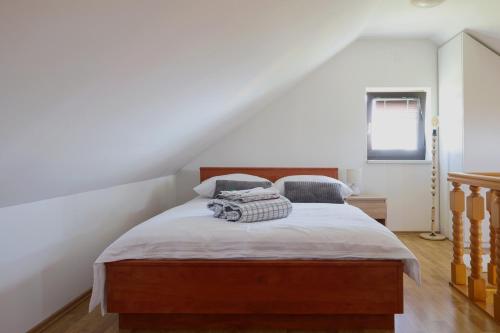 1 dormitorio con 1 cama con cabecero de madera en Small Hill Heaven en Varaždin Breg