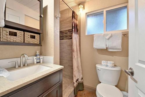 a bathroom with a sink and a toilet and a window at Whispering Woods Big Bear~ Central Resort Cottage~ in Big Bear Lake