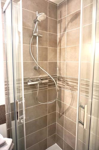 une douche avec pommeau de douche dans une salle de bain dans l'établissement Charmant studio centre ville, au Puy-en-Velay