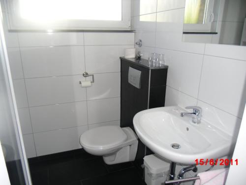 a bathroom with a white toilet and a sink at Centralhotel Ratingen in Ratingen