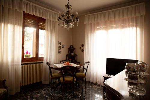 uma sala de jantar com uma mesa e um lustre em Casa Giuly em Parma