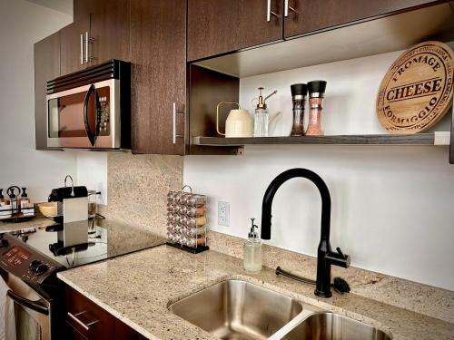 a kitchen with a sink and a counter top at ColoursNest - Downtown apt spectacular view and location in Calgary
