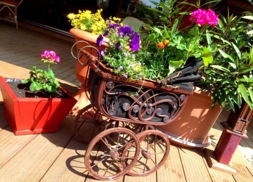 a cart full of flowers sitting on a porch at Ambrózia Étterem és Panzió in Kazincbarcika