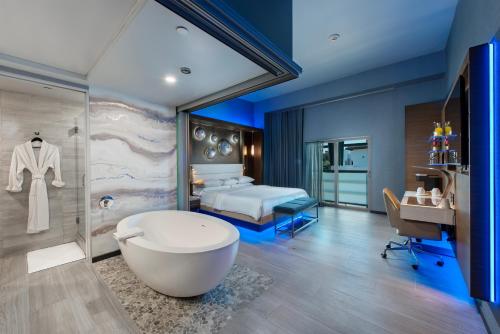 baño con bañera y cama en Shade Hotel Manhattan Beach, en Manhattan Beach