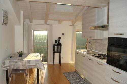 a kitchen with white cabinets and a table in it at Locazione Turistica Aquila in Verona
