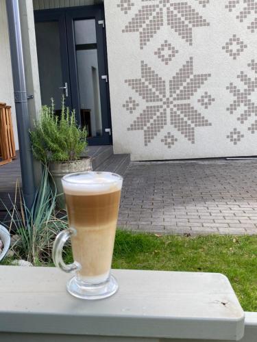 a cup of coffee sitting on a table at Apartamentai Ornamentai in Druskininkai