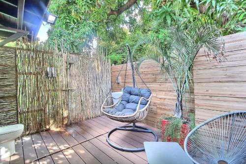 a swinging chair on a patio with a fence at Residence De La Cousiniere in Vieux-Habitants