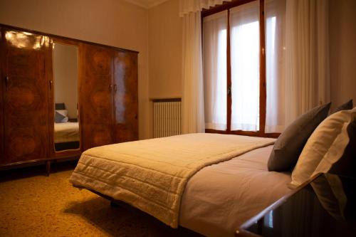 um quarto com uma cama e uma grande janela em Casa Giuly em Parma